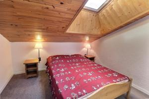 een slaapkamer met een rood bed en een houten plafond bij Residence Plan Du Lac in Mussillon