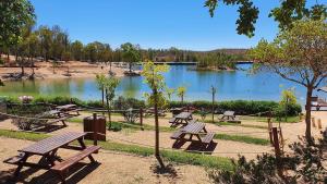 a group of picnic tables in front of a lake at Casa da Cerca in Corte do Pinto