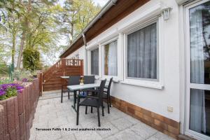 a patio with chairs and a table on the side of a house at Dünenhaus Fewos - Zum Strand 50m in Ueckeritz