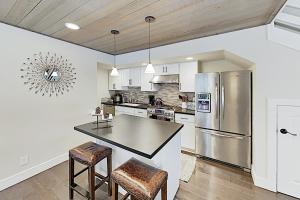 a kitchen with a stainless steel refrigerator and stools at Forest Pines Condo 1 - 46 in Incline Village