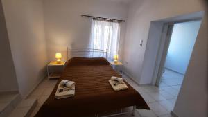 a bedroom with a bed with two towels on it at Aegina house1 in Aegina Town