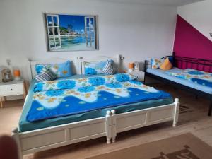 Schlafzimmer mit einem Bett mit blauer Decke in der Unterkunft marielies-urlaubsstube in Meißenheim
