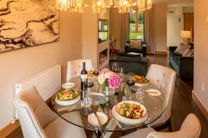 un comedor con una mesa con platos de comida en The Johnstown Estate Lodges en Enfield