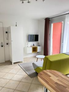 een woonkamer met een groene bank en een tv bij Fewo Petershausen in Konstanz