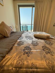 a bedroom with a bed with a view of the ocean at Pacific rak in Ras al Khaimah