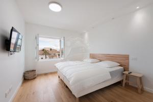 a white bedroom with a bed and a window at AS21778- Magnifique P3 avec terrasse au cœur du Centre ville dans une maison de caractère in Le Grau-du-Roi