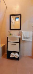a bathroom with a sink and a mirror at Las Casitas, cabañas & suites in Pincén +20 photos