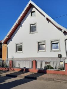 una casa blanca con una valla negra en marielies-urlaubsstube en Meißenheim