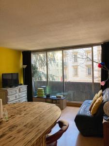 a living room with a table and a large window at Le Studio Victoria II -Mon Desert Village -27m2 in Nancy
