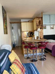 a kitchen with a table and stools in a room at Le Studio Victoria II -Mon Desert Village -27m2 in Nancy