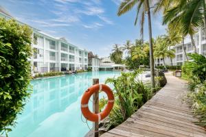 una piscina en un complejo con un salvavidas en Beach Club Port Douglas Luxury Apartments en Port Douglas