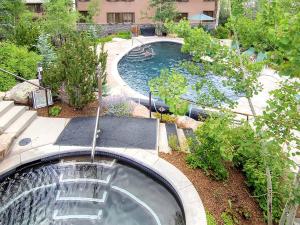 a swimming pool with a waterfall in a yard at Aspenwood by Snowmass Vacations in Snowmass Village