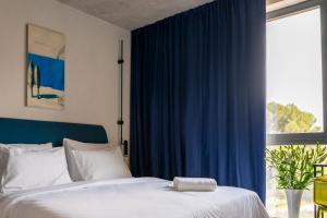 a bedroom with a bed with blue curtains and a window at Moro Inn in Korčula