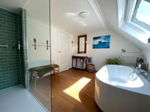 bagno con vasca e doccia in vetro di het opgemaakte bed a Haps