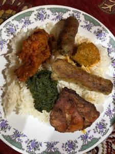 a plate of food with rice and meat and vegetables at The Puma house in Leh +30 photos