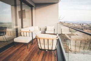 balcón con 2 sillas, mesa y ventana en Villa Vajta en Dobrovo