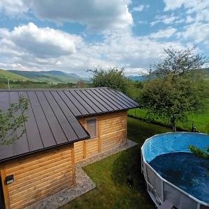 a large hot tub next to a wooden building at Apartment Sunny Place in Bihać