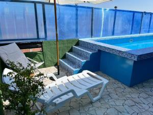 a white bench sitting next to a swimming pool at Hermoso mini departamento c/ entrada independiente in Piura