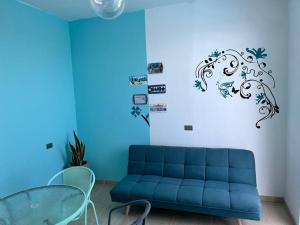 a living room with a blue couch and a table at Hermoso mini departamento c/ entrada independiente in Piura