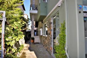 a narrow alleyway between two buildings with plants at Virginia Rooms in Olympiaki Akti