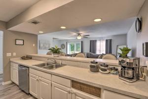 a kitchen with a sink and a living room at Updated Townhome with Deck about 12 Mi to Beaches! 
