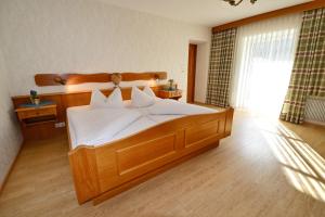ラムサウにあるGasthof Oberwirtのベッドルーム1室(白いシーツを使用した大きな木製ベッド1台付)