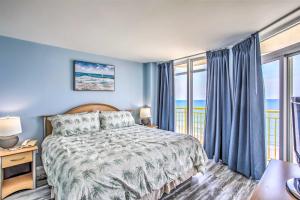 a bedroom with a bed with blue walls and windows at Beachside Retreat North Myrtle Beach Condo! in Myrtle Beach