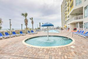 ein Schwimmbecken mit Stühlen und einem Sonnenschirm in der Unterkunft Ocean-View Balcony North Myrtle Beach Condo! in Myrtle Beach