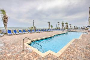 ein Swimmingpool mit Stühlen und das Meer im Hintergrund in der Unterkunft Ocean-View Balcony North Myrtle Beach Condo! in Myrtle Beach