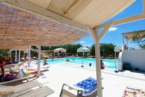 einen Pool mit Stühlen und Menschen im Wasser in der Unterkunft Agriturismo Le Matinelle in Matera