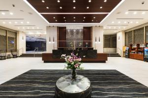 a lobby with a vase of flowers on a rug at APA Hotel Woodbridge in Iselin
