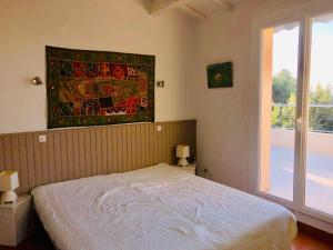 um quarto com uma cama e uma tapeçaria na parede em Villa avec piscine au Lavandou dans jardin méditerranéen em Le Lavandou