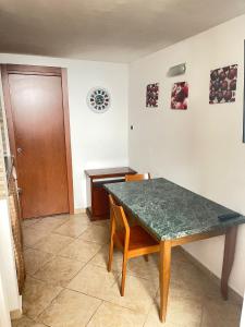 ein Esszimmer mit einem grünen Tisch und einer Holztür in der Unterkunft Al Corso in Molfetta