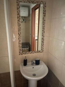 ein Bad mit einem Waschbecken und einem Spiegel in der Unterkunft Al Corso in Molfetta