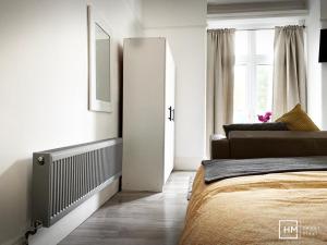 a white bedroom with a bed and a window at Norbury House - Apratment 1b in Norbury
