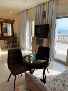 a living room with a television and a table and chairs at Apartments Villa Isabella in Opatija