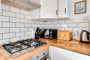 uma bancada de cozinha com um forno com placa de fogão em Tasteful 3-Bedroom House with private parking - Florence Park em Oxford