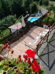 a patio with a pool and a chair and flowers at La Sorgente Appartamento con piscina privata in Calice Ligure