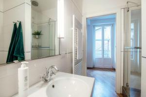 Un baño blanco con lavabo y espejo. en Vicolo Dei Pescatori - by MyHomeInComo, en Argegno 25 fotos más