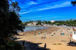 a group of people sitting on a beach at Royan - Agréable Duplex Plage de Nauzan in Vaux-sur-Mer