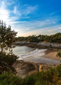 a beach with rocks and the ocean on a sunny day at Royan - Agréable Duplex Plage de Nauzan in Vaux-sur-Mer +17 photos