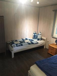 a small bedroom with a bed with blue and white sheets at Ferienhaus 8 am See in Granzow in Mirow