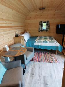 a bedroom with a bed and a table in a room at Oak Lodge Pods in Saint Lawrence