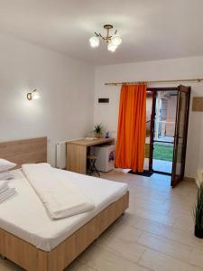 a bedroom with a large bed and a desk at Casa Ella in 2 Mai
