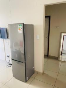 a stainless steel refrigerator sitting in a room at E & P Cave in Swakopmund