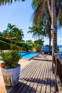 a resort with a swimming pool and palm trees at Casa com Vista inigualável "Vista del Lago" in Capitólio