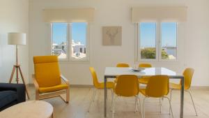 Un comedor con una mesa y sillas amarillas. en Blancazul El Marisco, en Playa Blanca