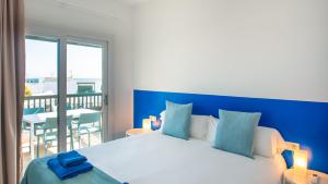 1 dormitorio con 1 cama con cabecero azul y balcón en Blancazul El Marisco, en Playa Blanca