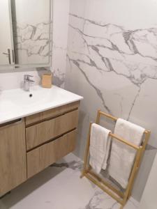 een badkamer met een wastafel en een spiegel bij TMJ Apartamento in Porto