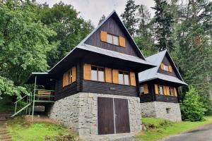 ein Haus mit einem schwarzen Dach und einer Steinmauer in der Unterkunft Turisticky Raj in Hrabušice